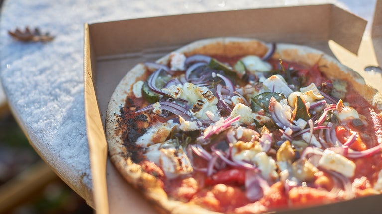 Wood fired pizza on a picnic table outdoors in winter